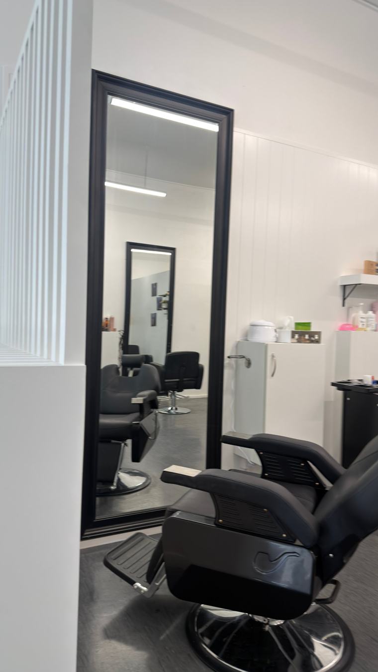 Tall black-framed mirror and treatment chair at Nova Hair & Beauty