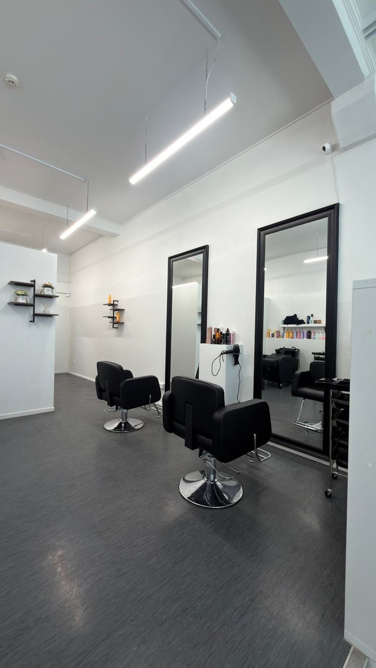 Two styling chairs in front of large black-framed mirrors at Nova Hair & Beauty